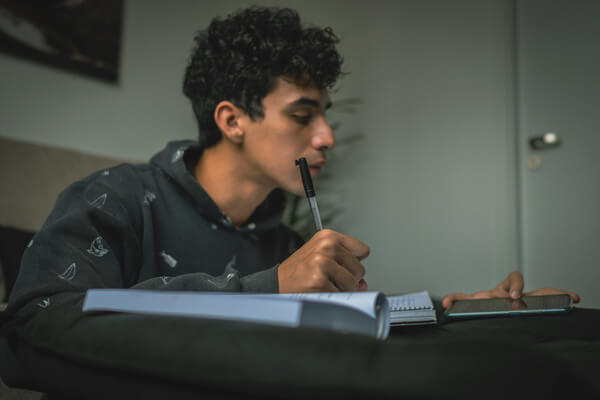a student using his phone and books to study