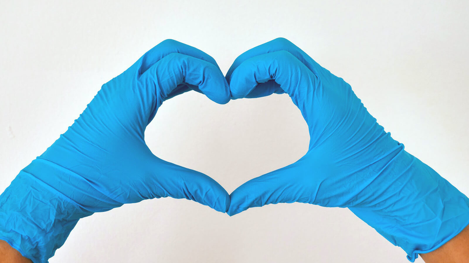 hands wearing medical gloves in the shape of a heart